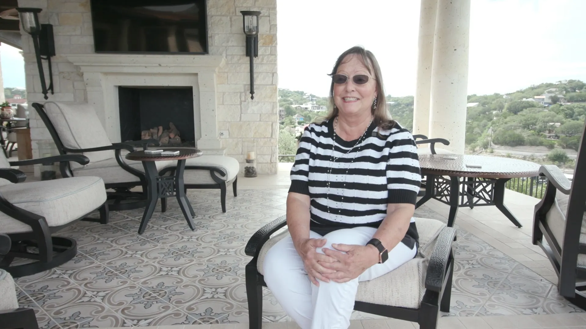 A homeowner smiling on her covered terrace above the Hill Country