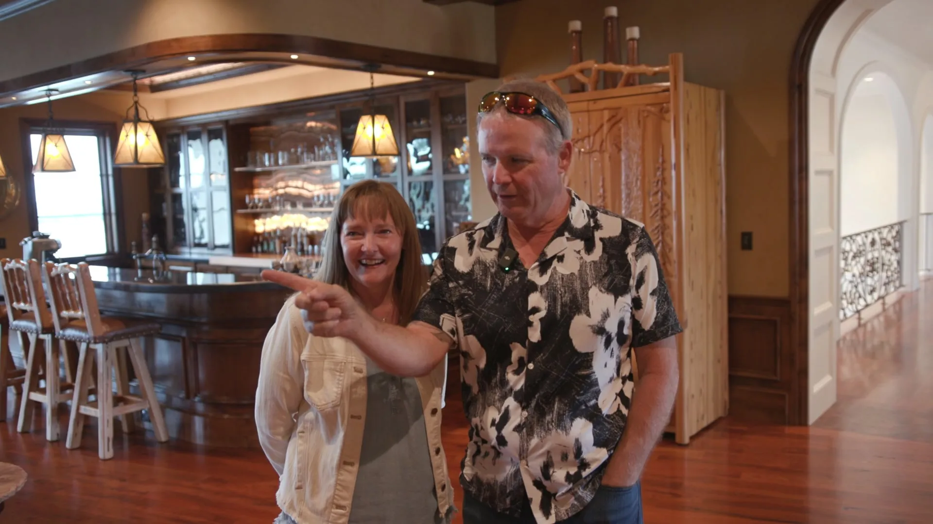 A couple laughing in their bar and wine room