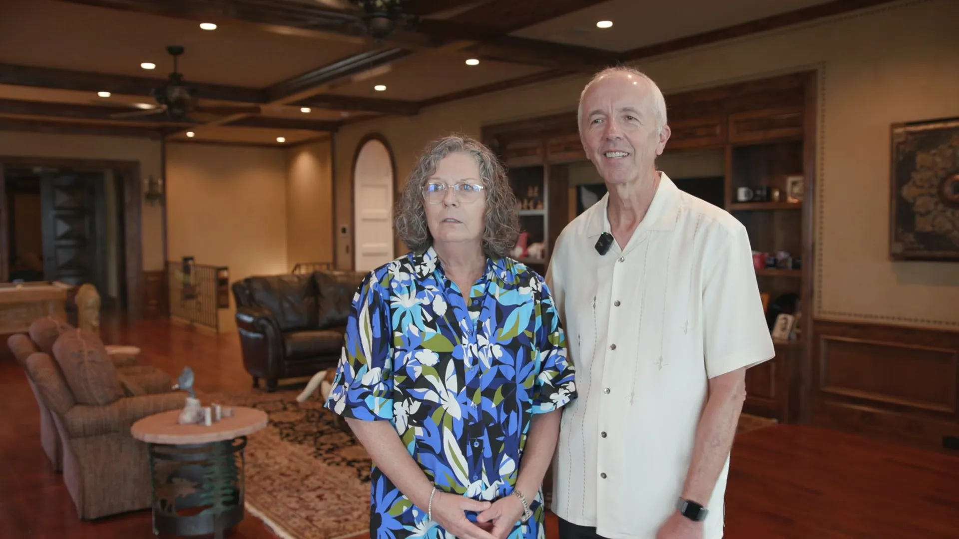 A couple standing together in a wood-paneled great room