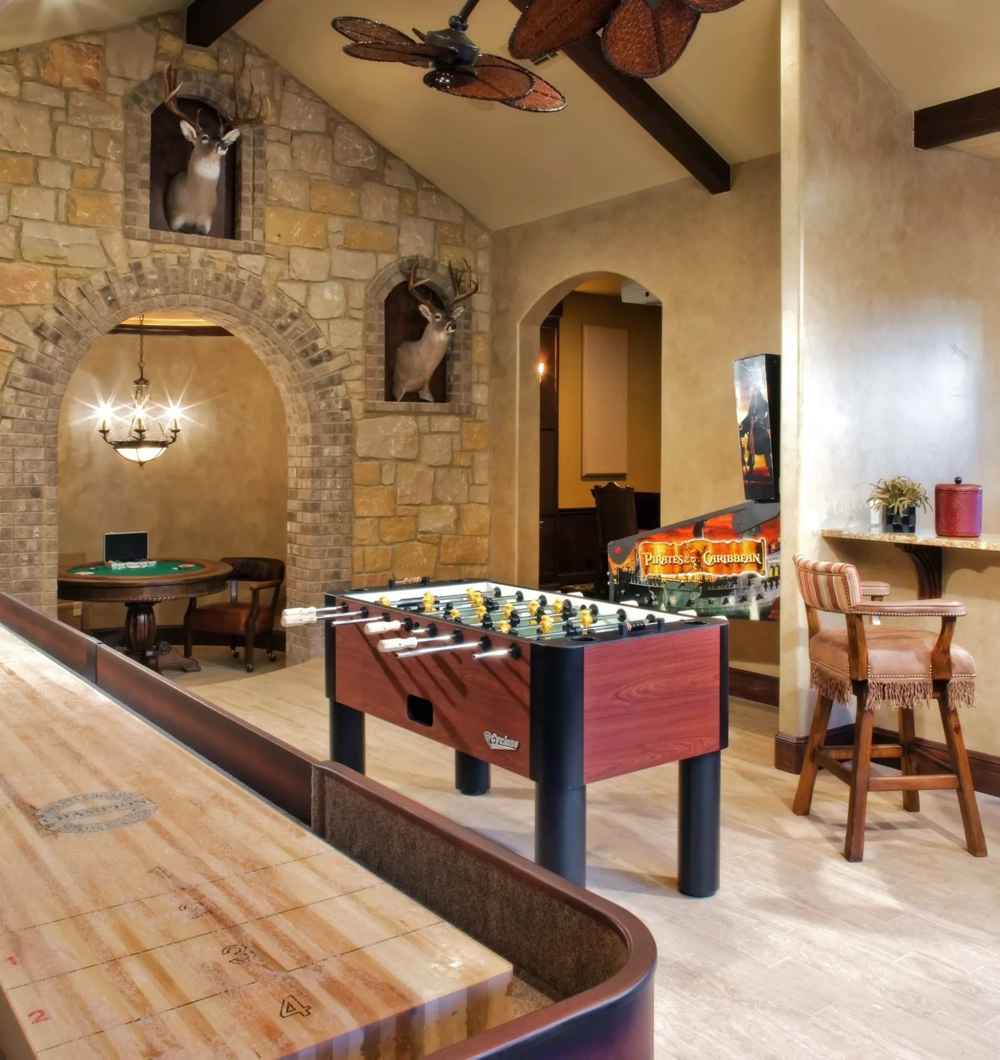 Game room with shuffleboard, foosball table and stone arch to a card table, Mediterranean Parade Home