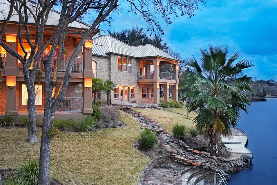 Limestone lake house above a stone-lined Lake LBJ shoreline in Horseshoe Bay