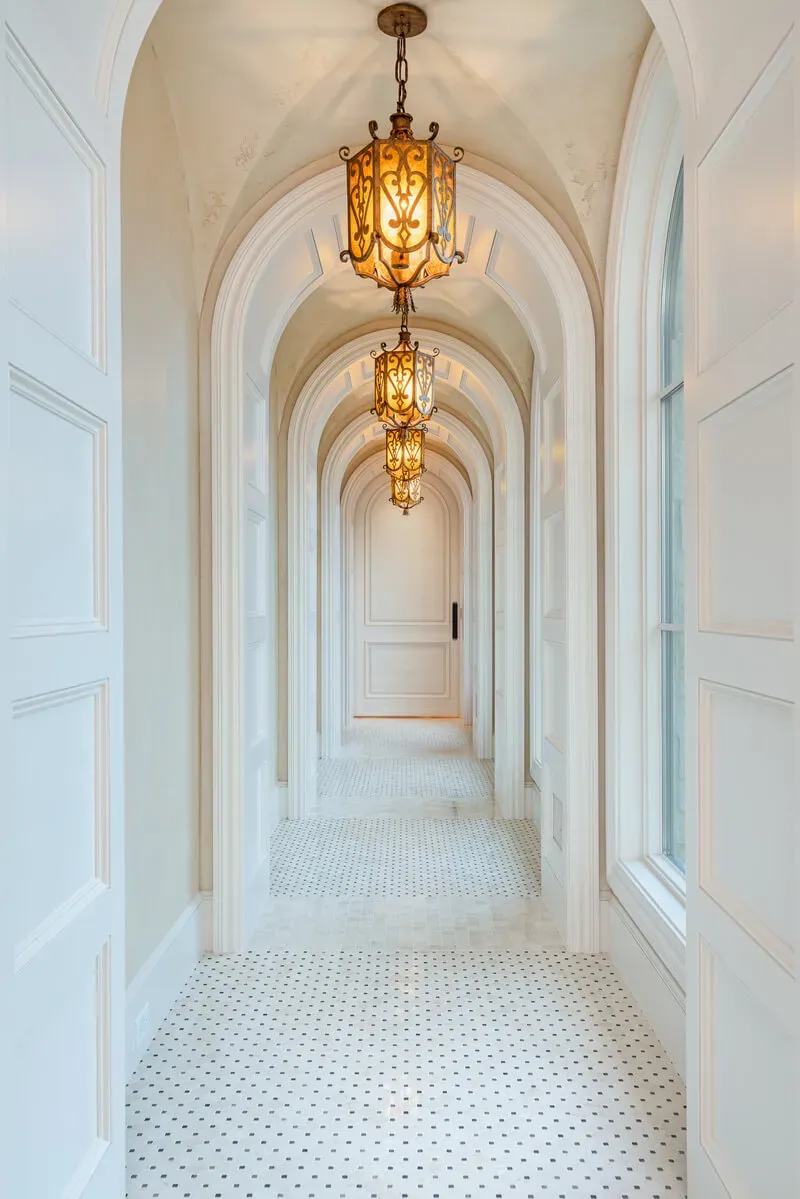 arched hallway with marble floor and lantern lights