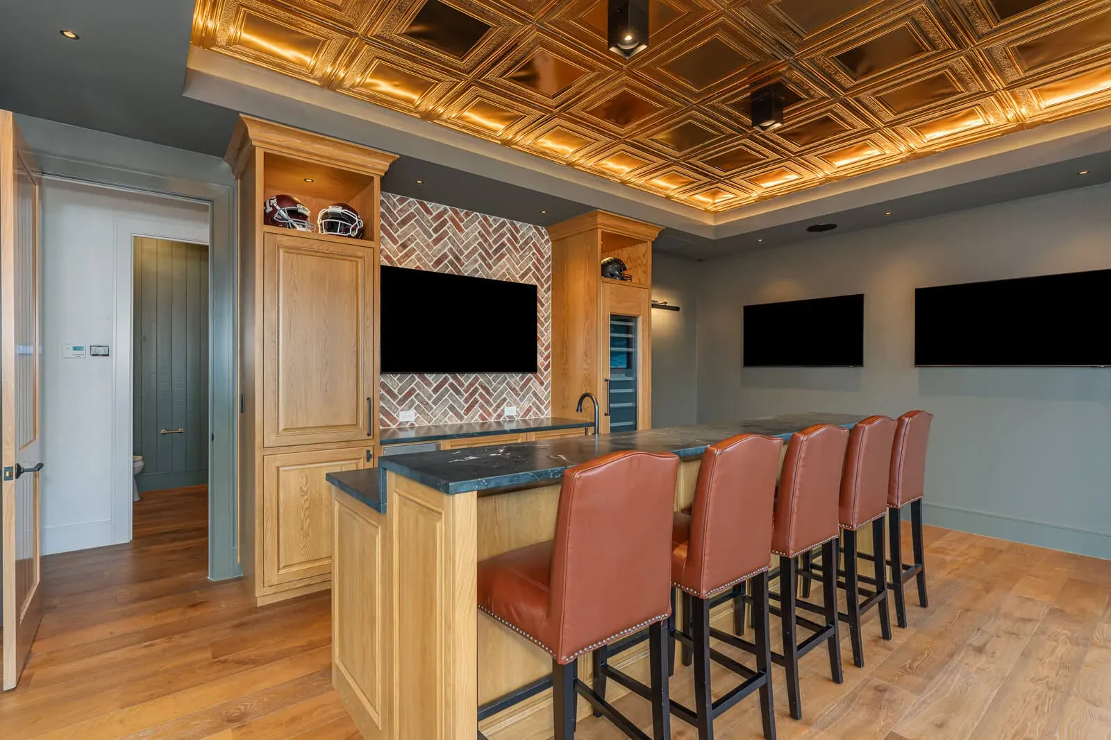 Austin home bar with leather stools and gold ceiling tiles