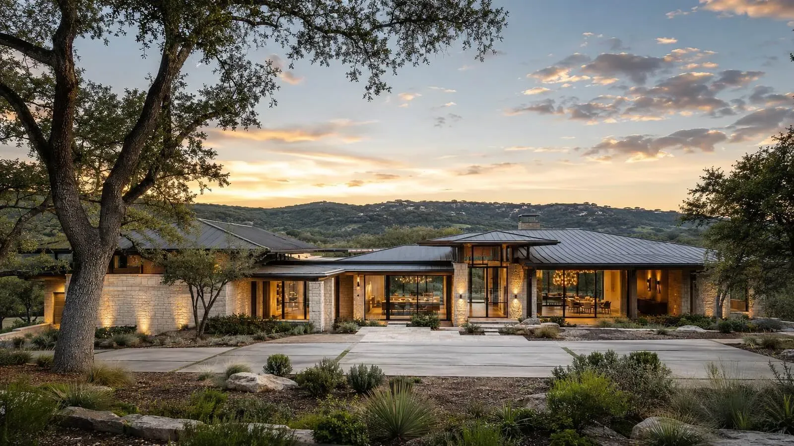 Flagship modern luxury custom home in Austin at golden hour with limestone, glass, and Hill Country views
