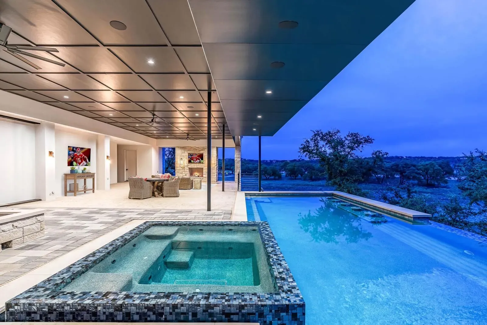 Custom spa and pool with fire feature and ambient lighting in the Texas Hill Country