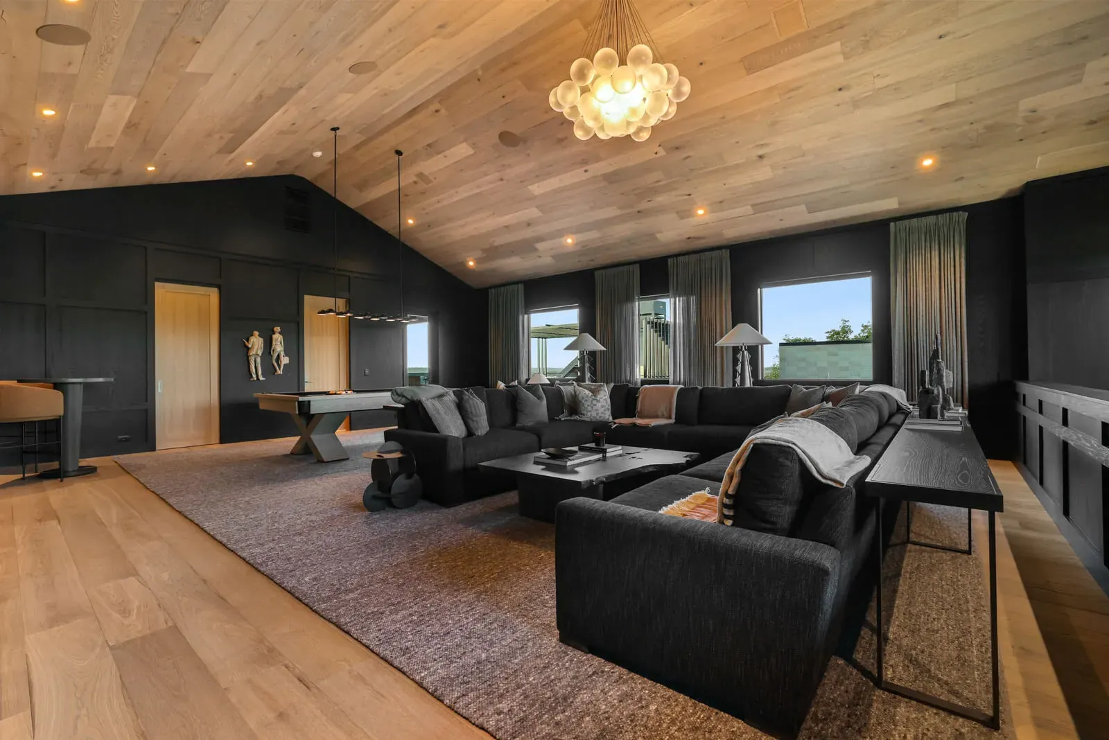 Spacious media room with dark walls and vaulted wood ceiling