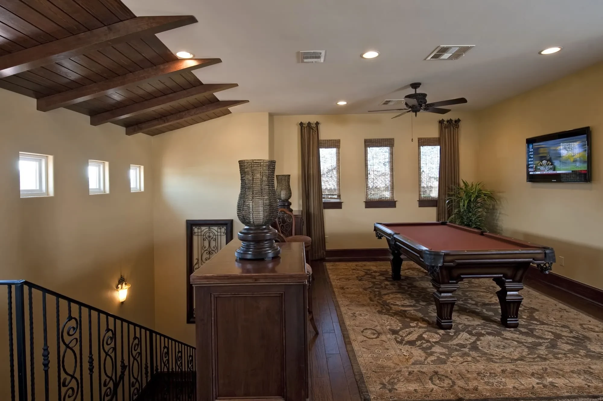 Upstairs game room with pool table and wrought iron stair railing, Modern Mediterranean Parade Home
