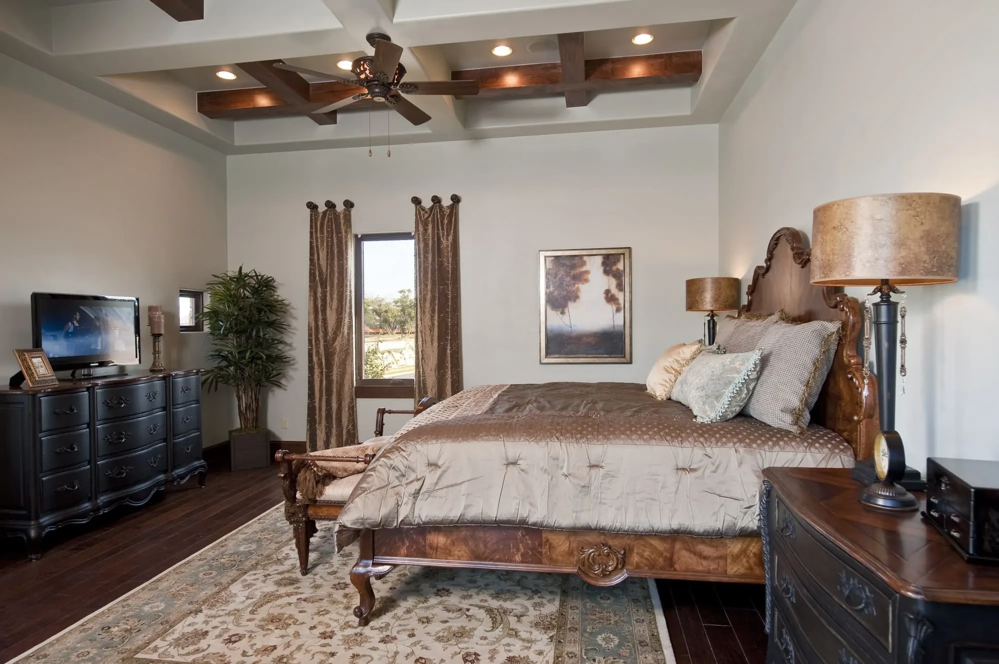 Bedroom with coffered ceiling, black dresser with TV and a window, Modern Mediterranean Parade Home