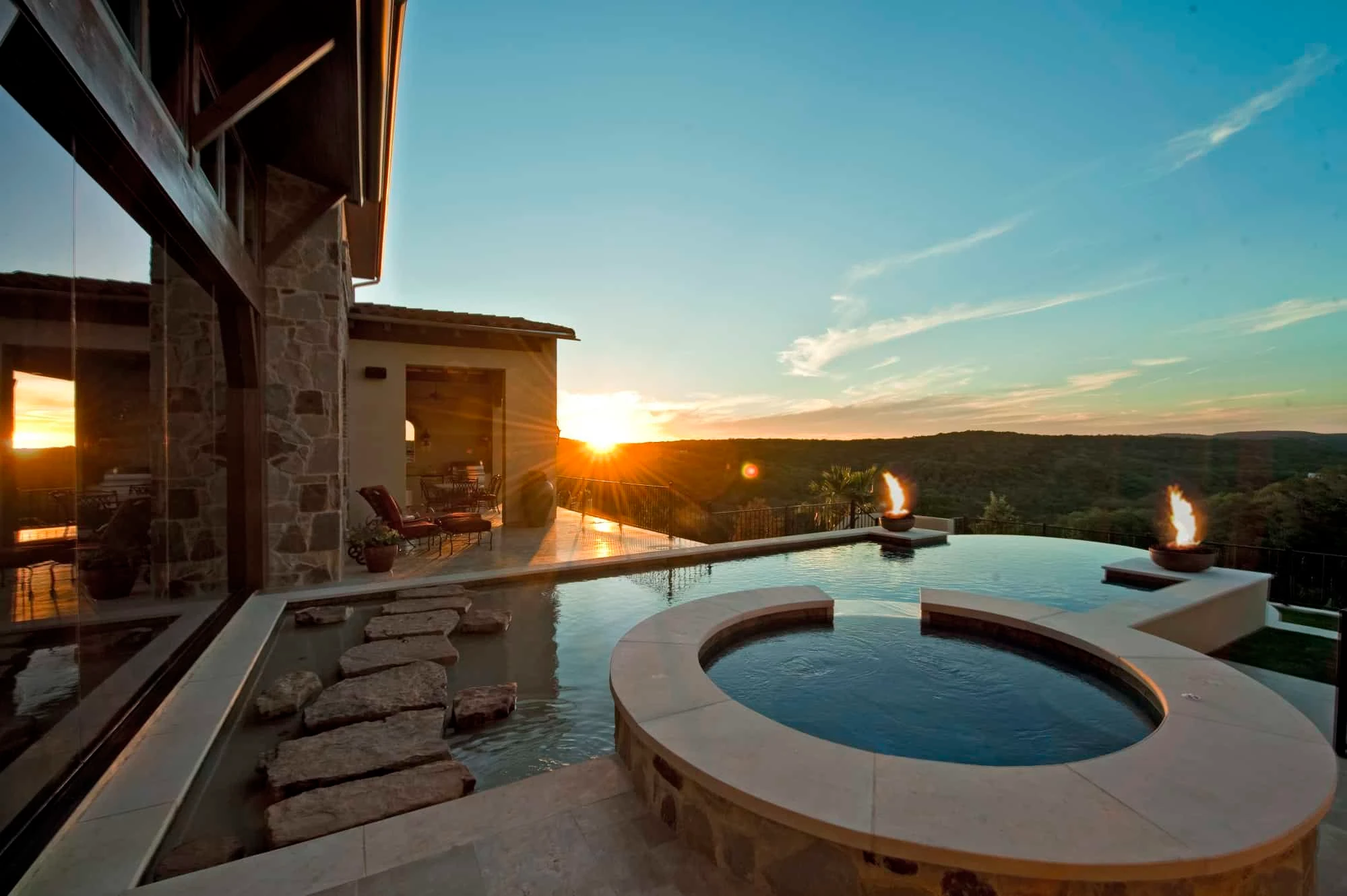 Sunset over wooded hills from the pool deck with spa and fire bowls, Modern Mediterranean Parade Home