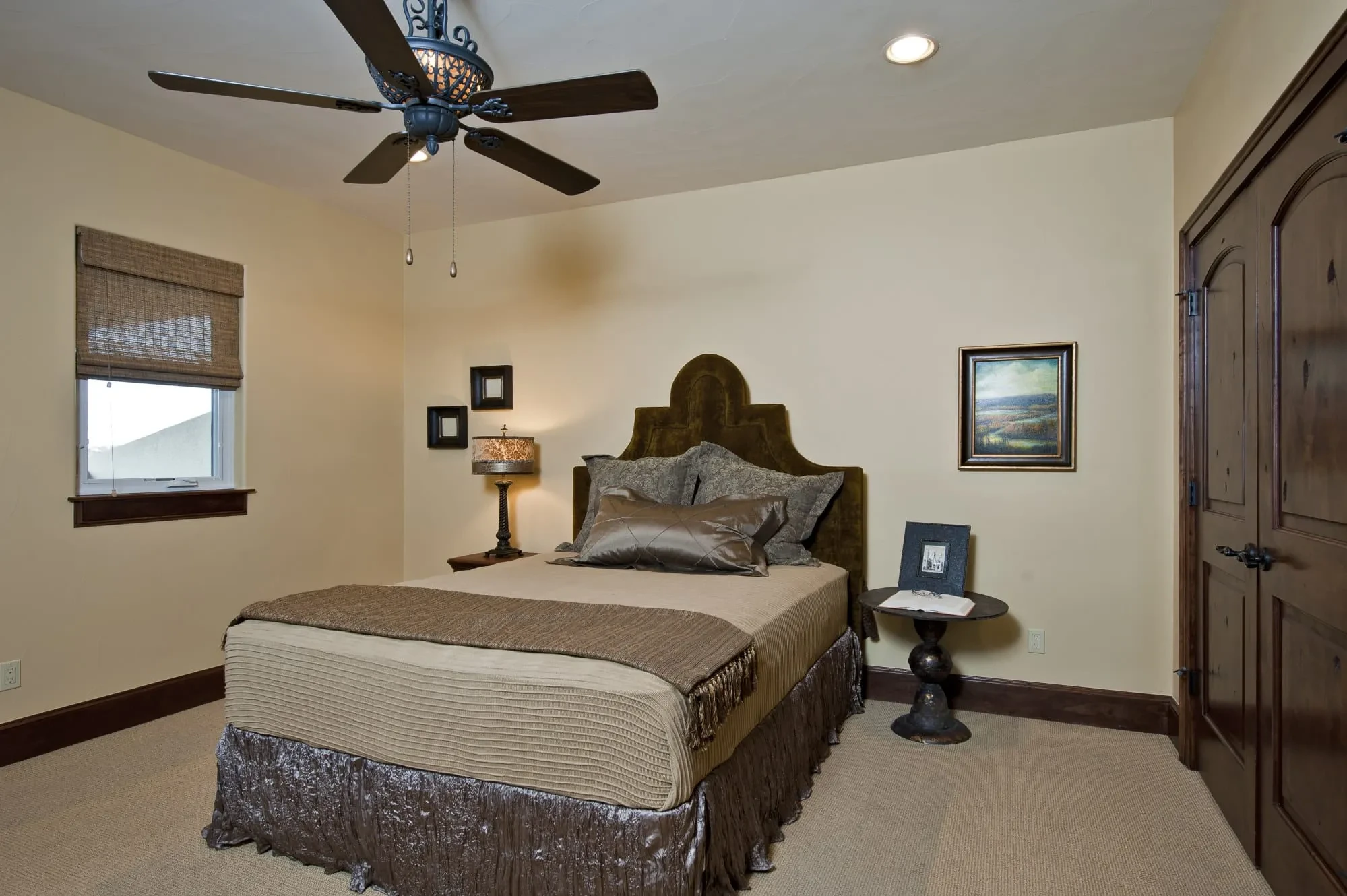 Bedroom with upholstered headboard, iron ceiling fan and arched-panel wood doors, Modern Mediterranean Parade Home