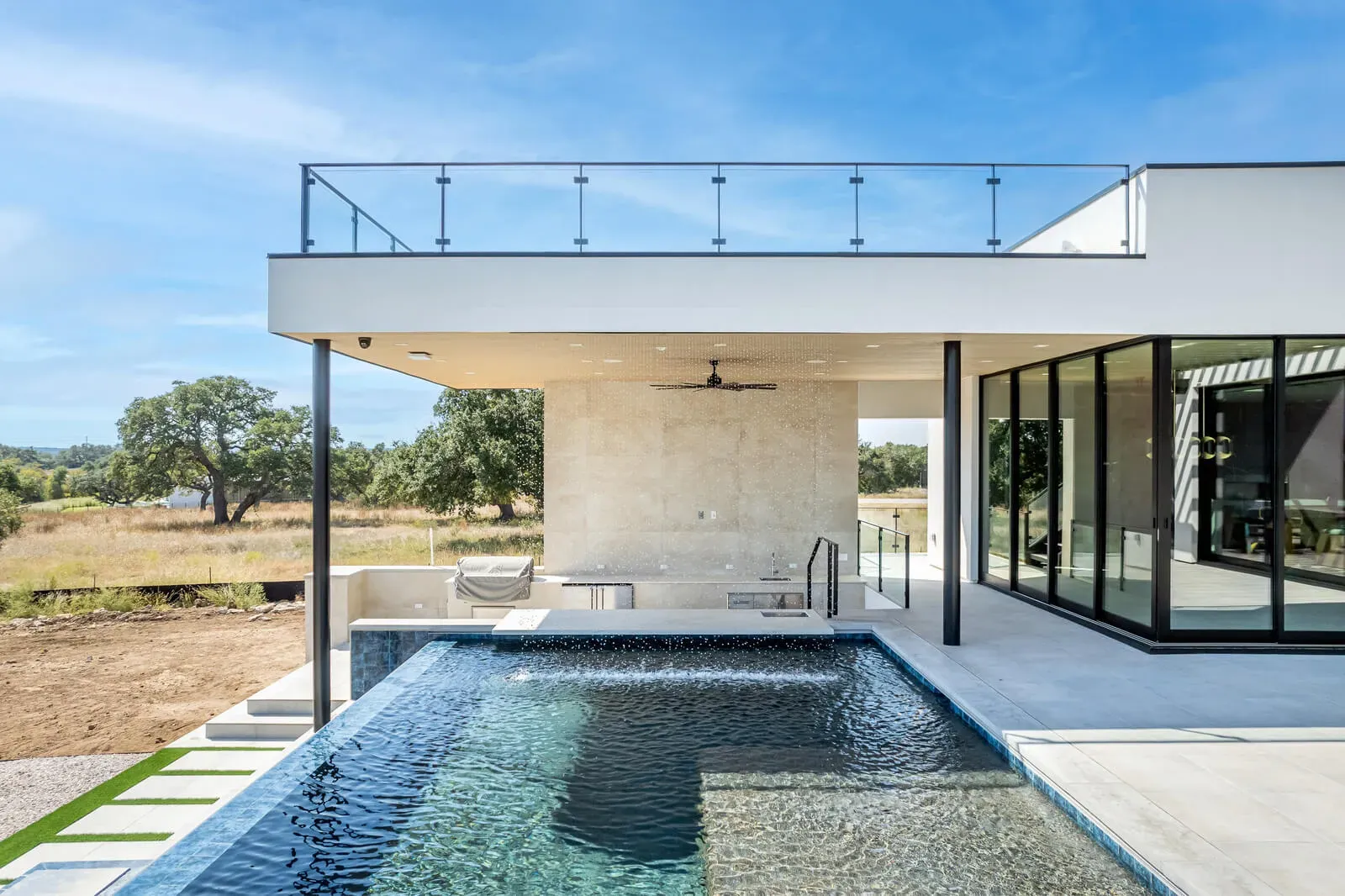 Contemporary pool design with clean lines and a covered patio in Central Texas