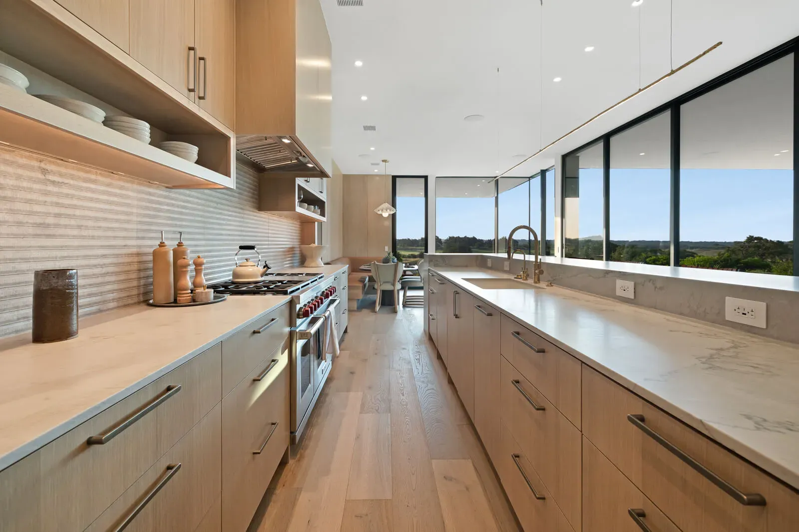 Hill Country luxury kitchen with long marble island, wood cabinetry, and expansive windows