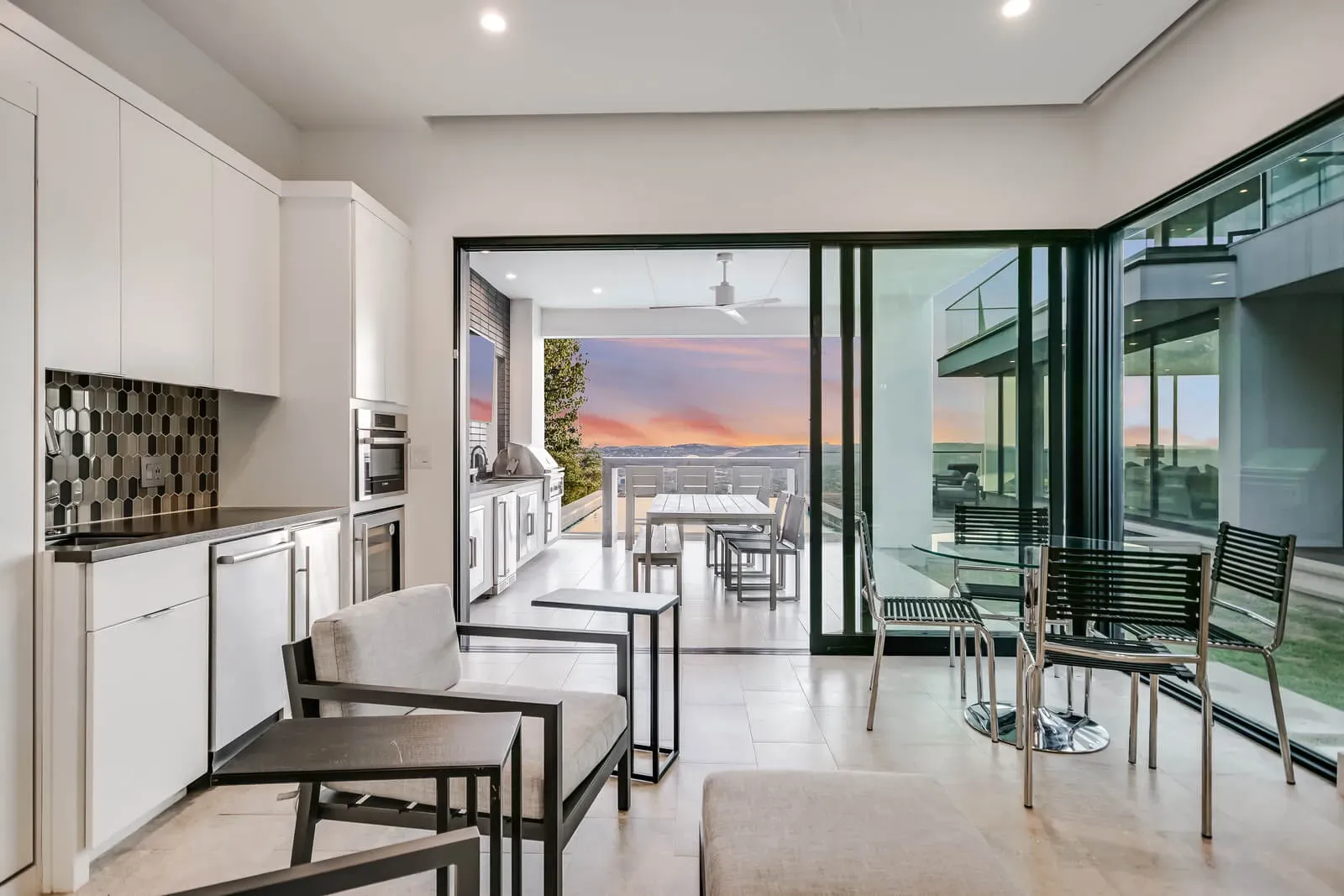 Indoor-outdoor casita kitchen with sunset views over the Texas Hill Country in a luxury multigenerational custom home by Jenkins Design Build