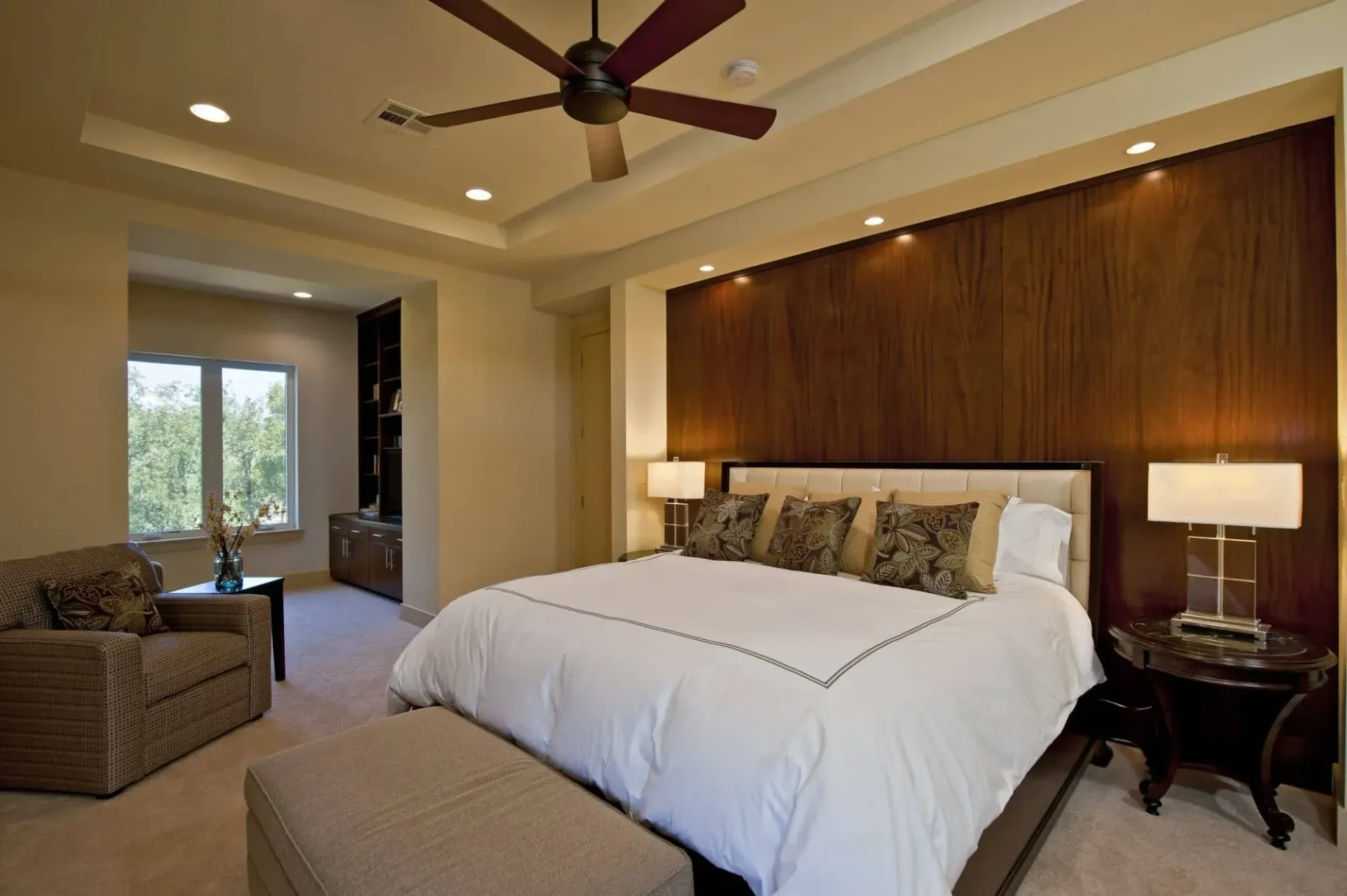 Primary suite in a single-story luxury home opening to a lake view