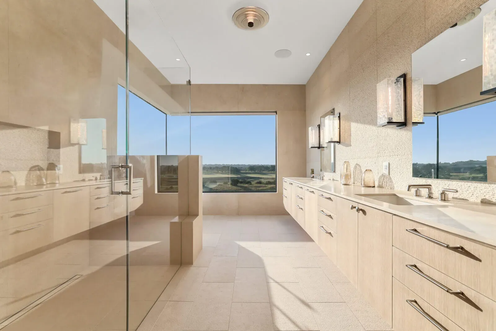 Luxury primary suite spa shower with corner window seat in Austin custom home