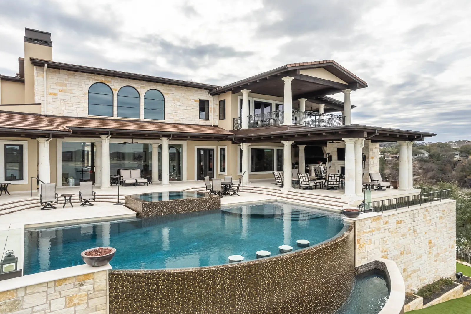 Resort-style pools by Austin luxury home builders featuring a luxury infinity-edge design and elevated patio in Westlake