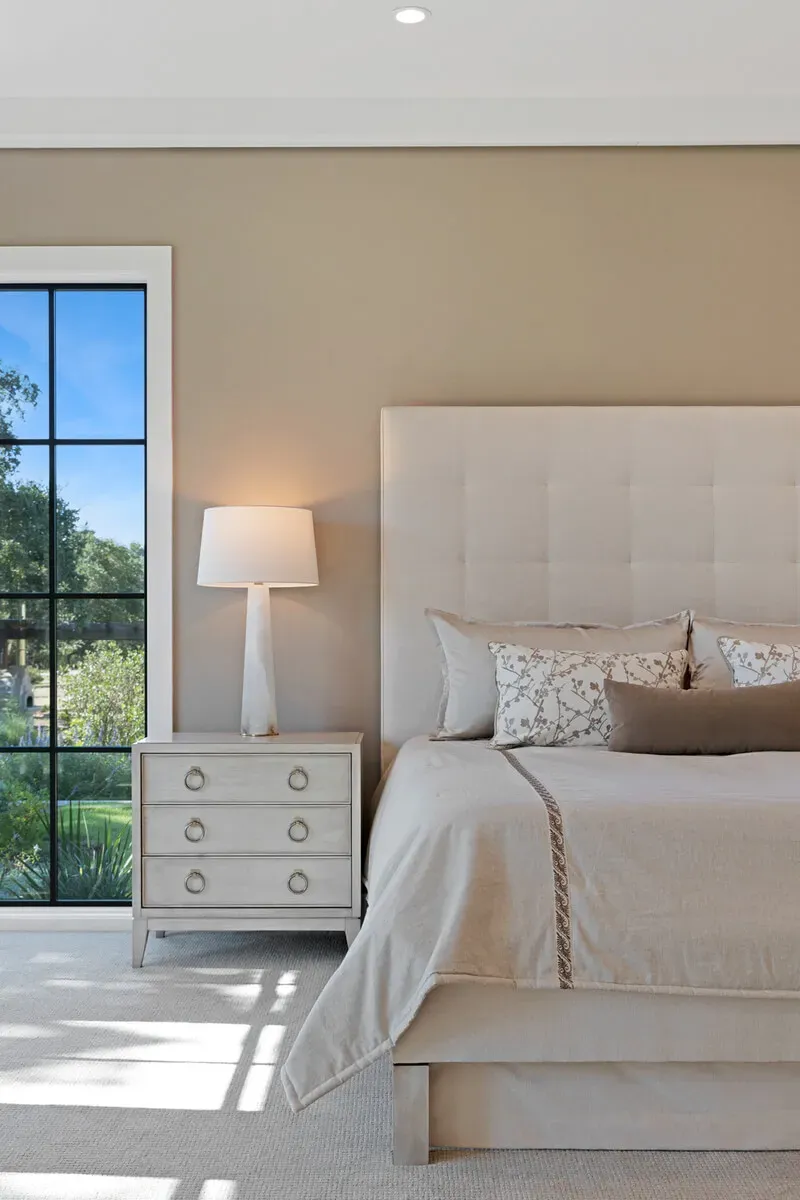 Serene owners suite bedroom filled with natural light and neutral tones in a Jenkins Design Build luxury custom home