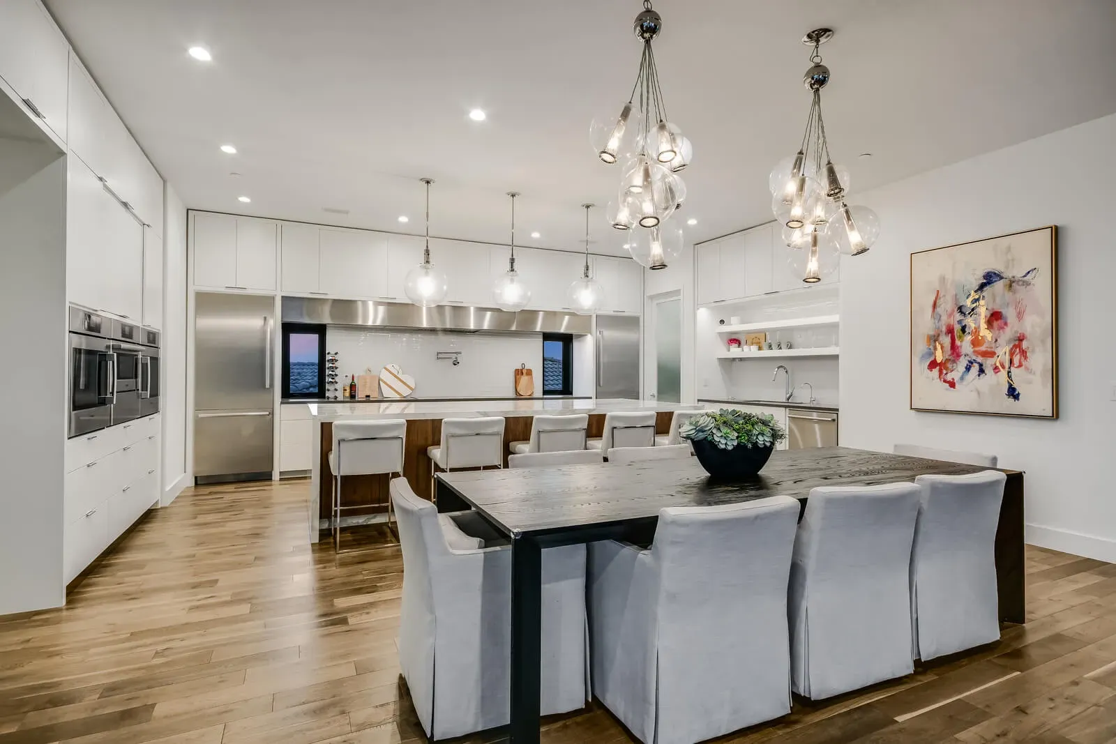 Timeless modern kitchen in Austin with white cabinetry, statement lighting, and spacious island