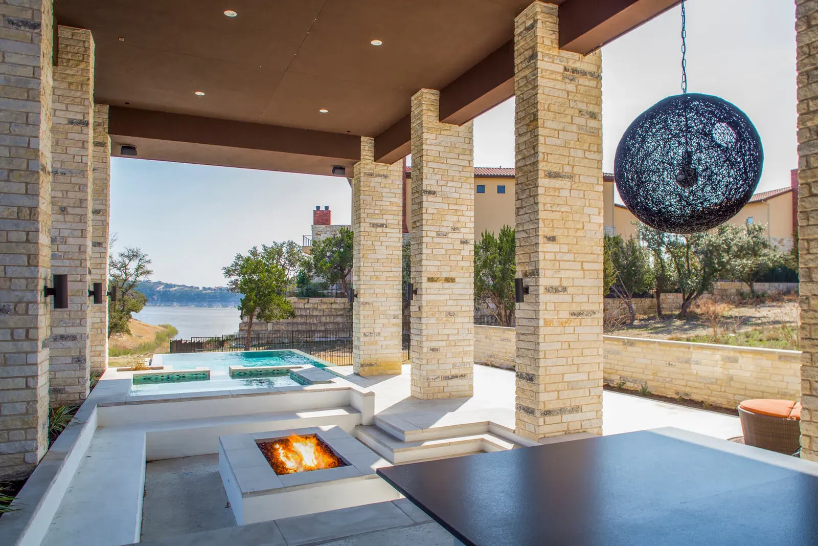 Resort-style pool with fire feature and lakefront view near Lake Travis by Austin luxury home builders